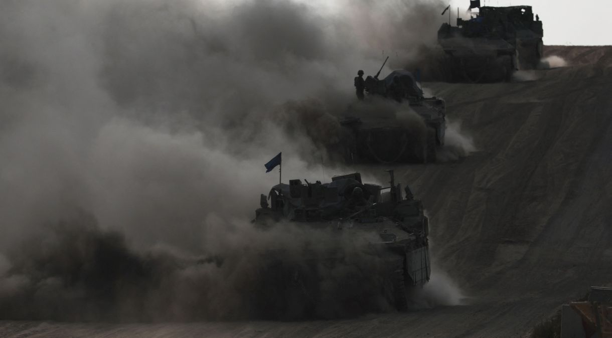 Veículos blindados de transporte de pessoal israelenses operam em meio ao conflito em curso entre Israel e o Hamas, perto da fronteira de Israel com Gaza, no sul de Israel
