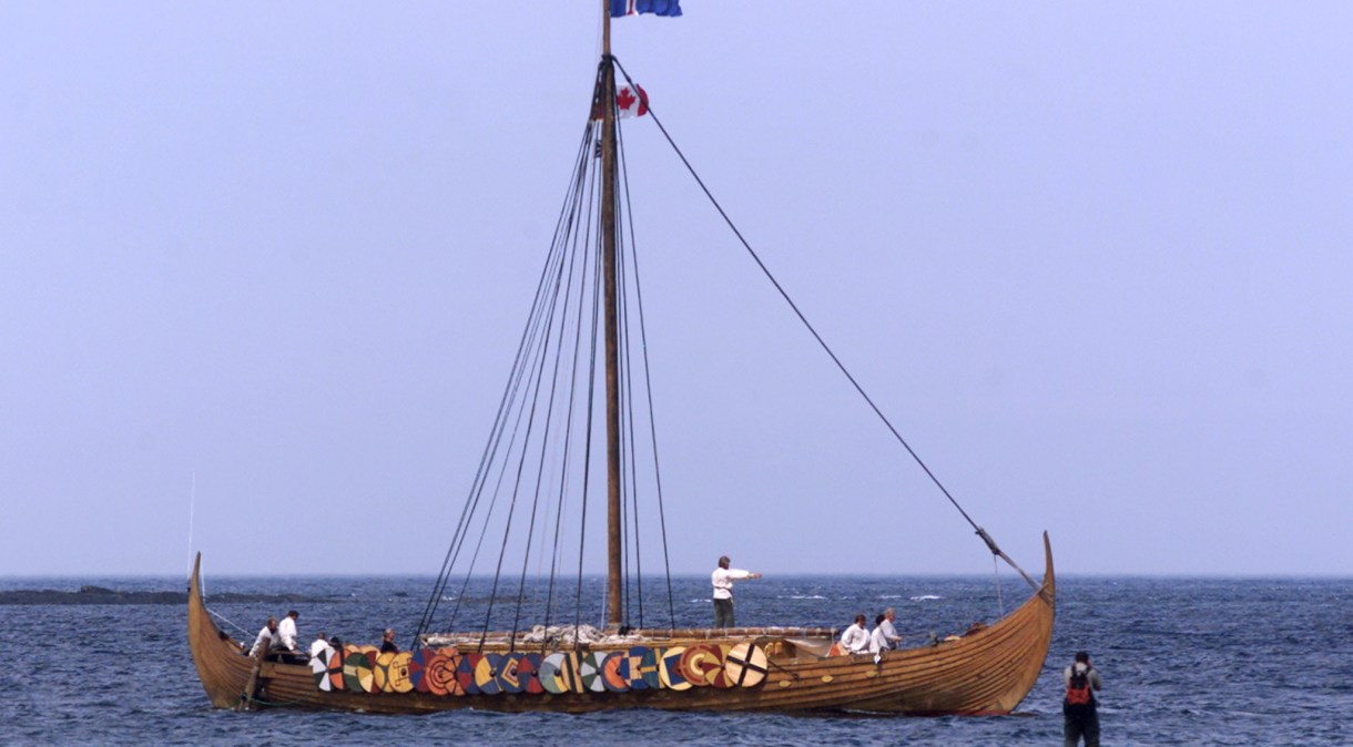 Turista fotografa réplica de embarcação viking na vila de pescadores de L'Anse aux Meadows, na ilha canadense de Newfoundland