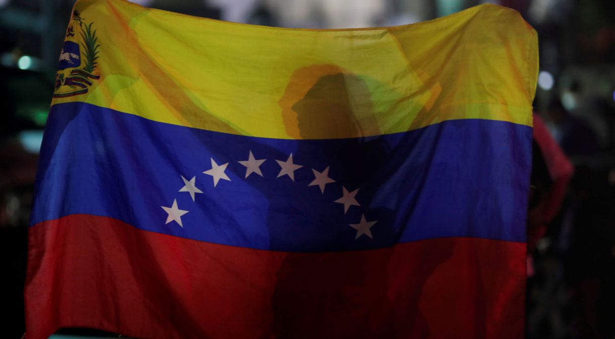 Mulher segura bandeira da Venezuela durante vigília em Caracas