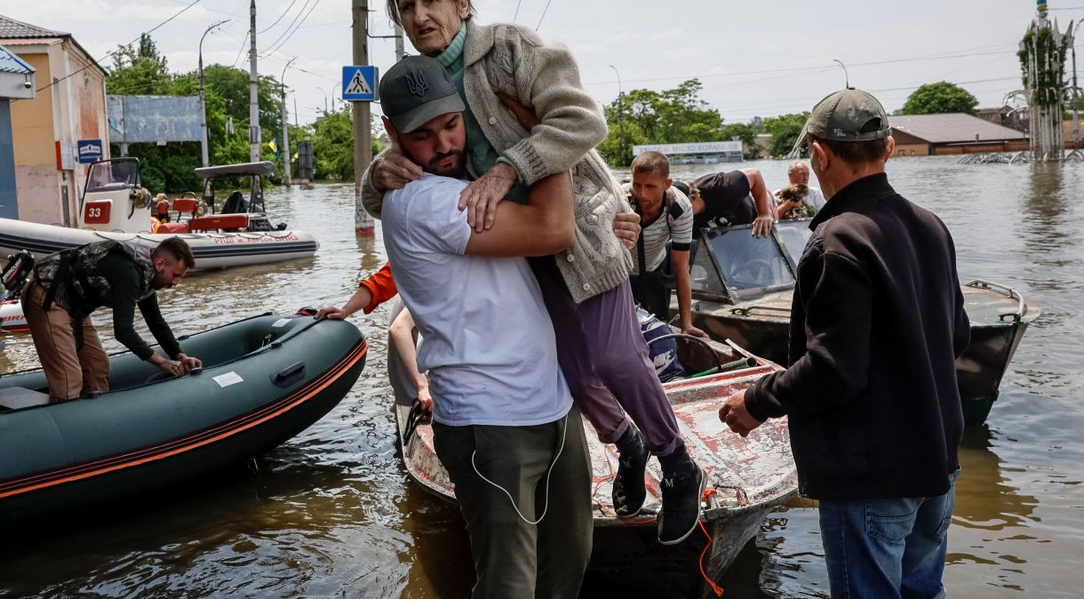 Voluntários retiram moradores de área inundada após rompimento da barragem de Nova Kakhovka, em Kherson; região foi bombardeada pelos russos