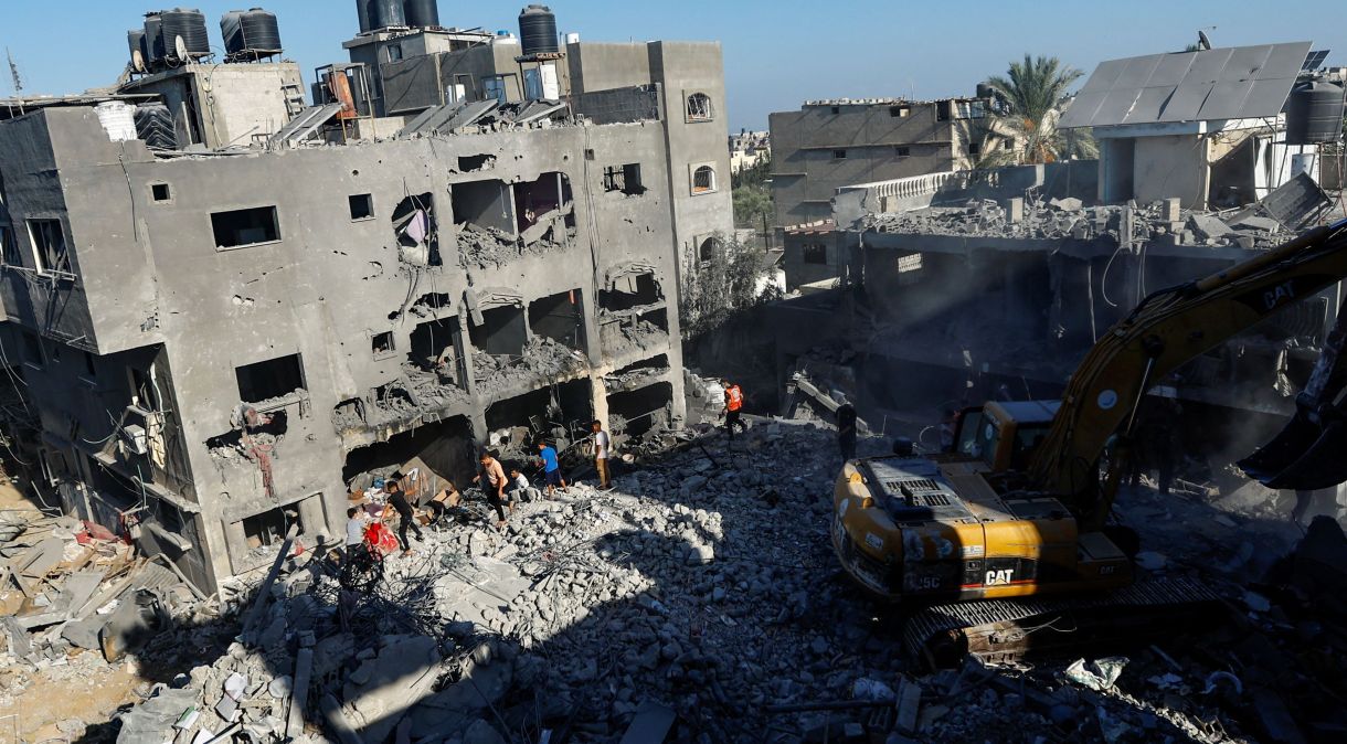 Palestinos realizam trabalho de resgate em meio a escombros após ataque israelense em Khan Younis, no sul da Faixa de Gaza