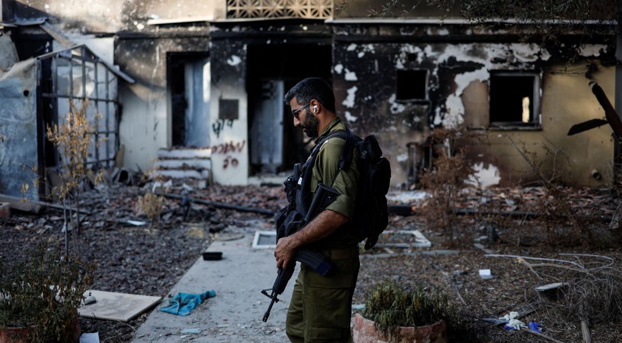Soldado israelense caminha por casa destruída por ataque do Hamas no kibutz de Beeri, no sul de Israel