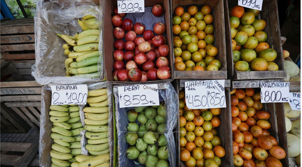 Imagem combinada mostra cartazes em mercado anunciando preços de vegetais e frutas em 8 de dezembro de 2023 (acima) e em 8 de janeiro de 2024 (abaixo), em Buenos Aires , Argentina