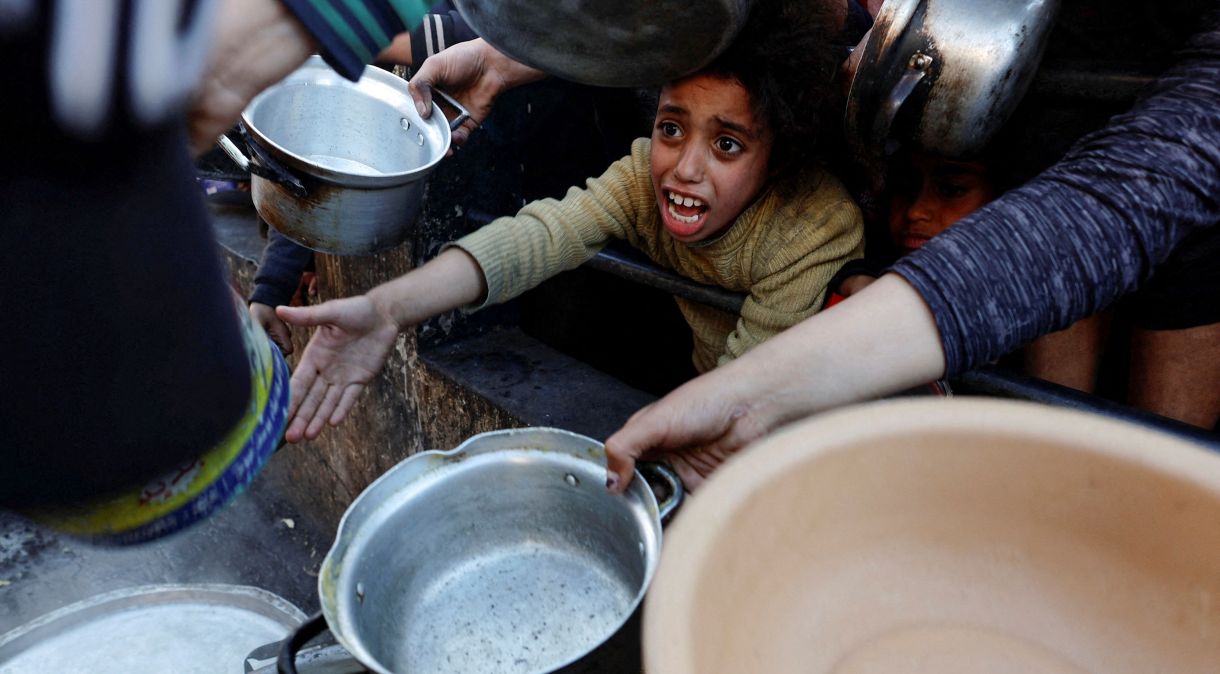 Palestinos esperam para receber comida durante o mês sagrado de jejum muçulmano do Ramadã em Rafah, sul da Faixa de Gaza