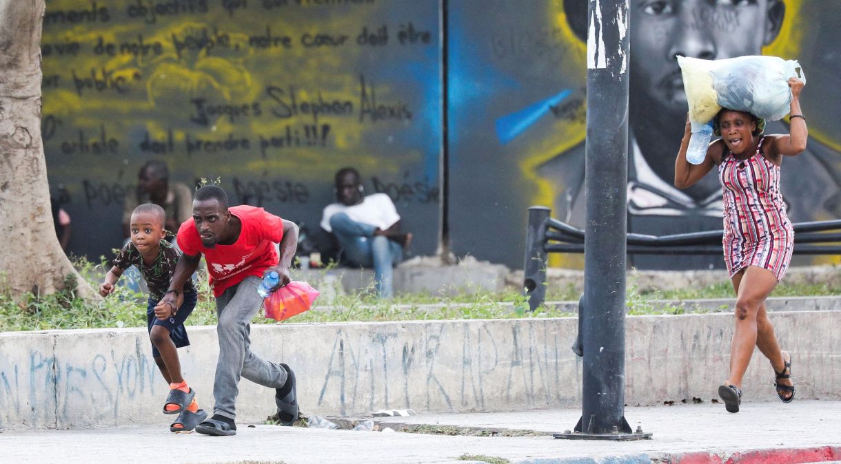 Pessoas se protegem de tiros perto do Palácio Nacional em Porto Príncipe, Haiti